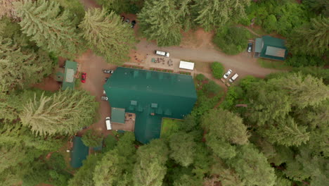 top down aerial slider shot over a large camp house in the woods