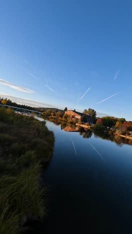 el avión no tripulado vuela a lo largo del río en la ciudad mientras los pájaros pasan por encima
