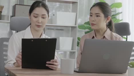 two young enthusiastic businesswoman working together in the office workspace.