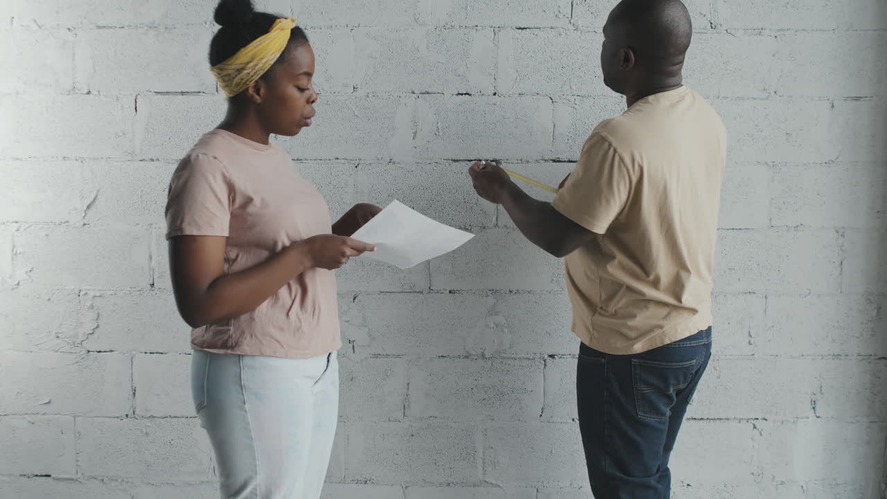 Couple Measuring Wall for Home Improvement