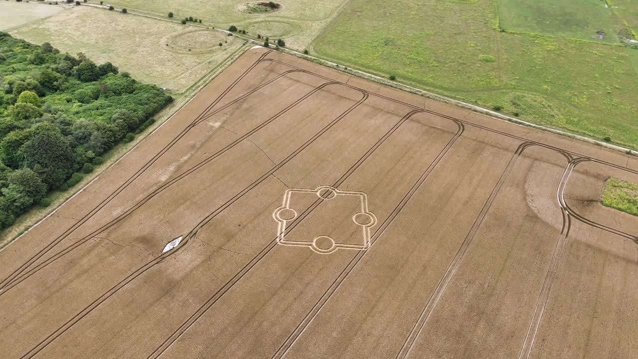 estableciendo una vista aérea con vistas al círculo de cultivo de stone henge y al campo rural de tierras de cultivo doradas