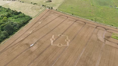 Establishing aerial view overlooking stone henge crop circle and rural golden farmland countryside