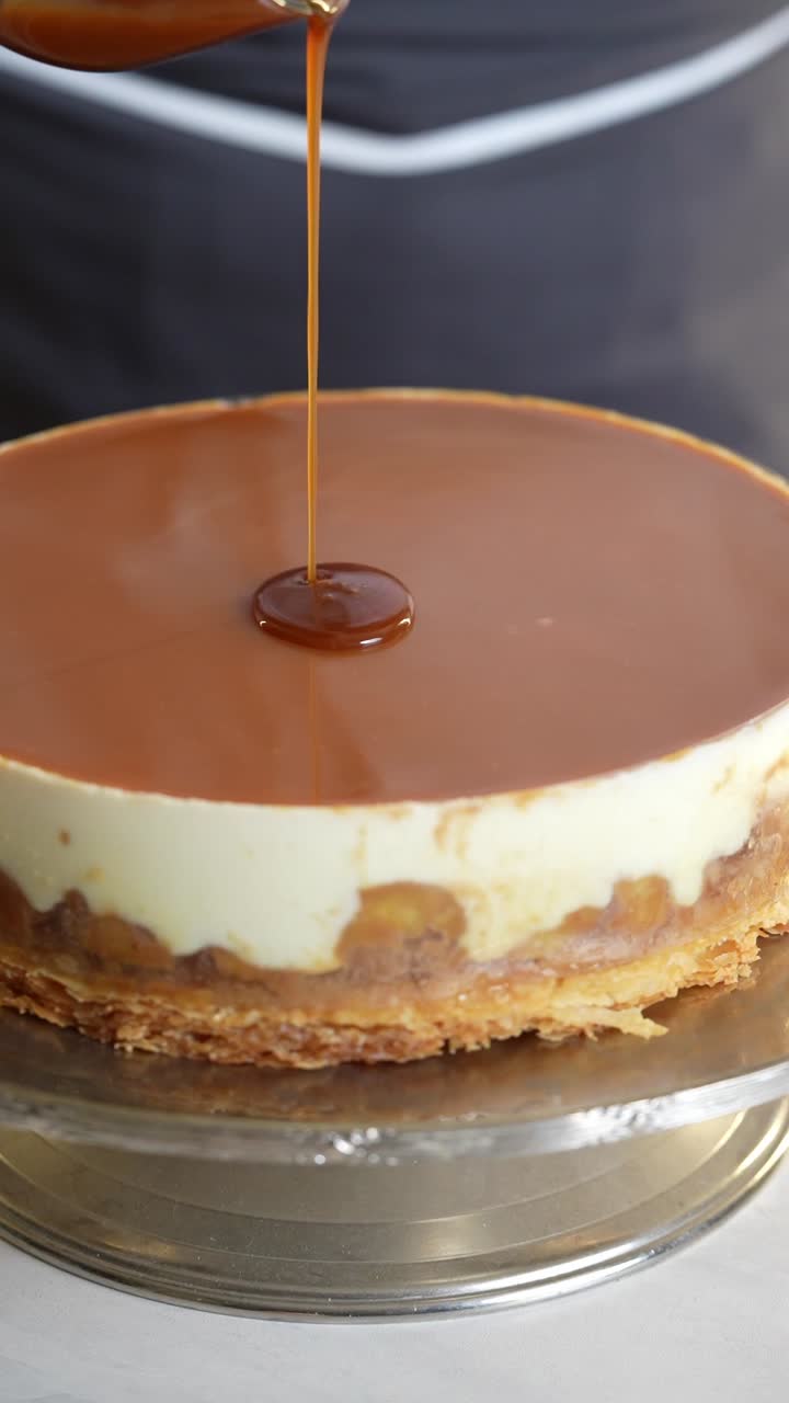 A chief put a caramel sauce to a cake, close up shot, insert shot