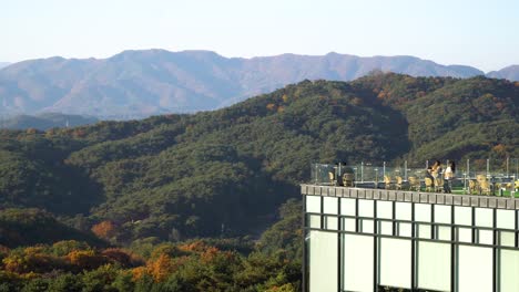 gente sentada en la cafetería de la azotea con hermosas vistas a las montañas