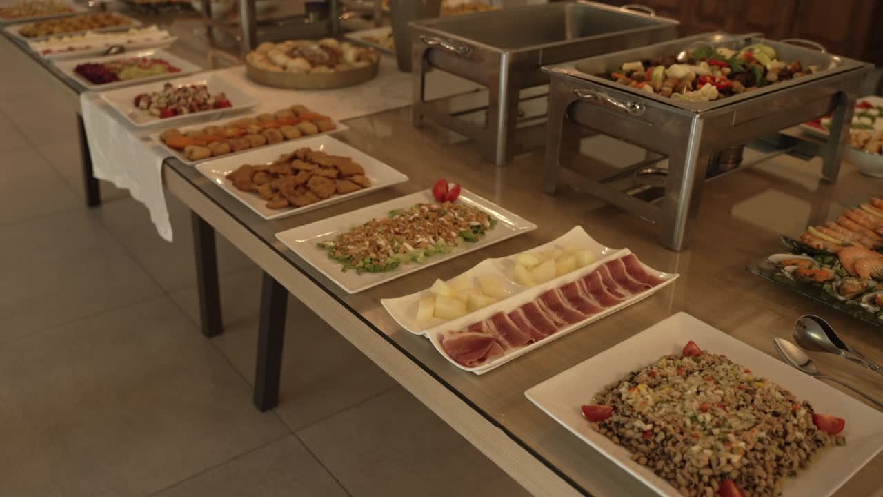 Buffet table with an assortment of appetizers and main dishes, set for a formal event