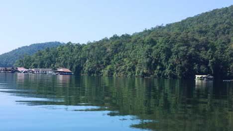 calm water reflects forest and floating homes