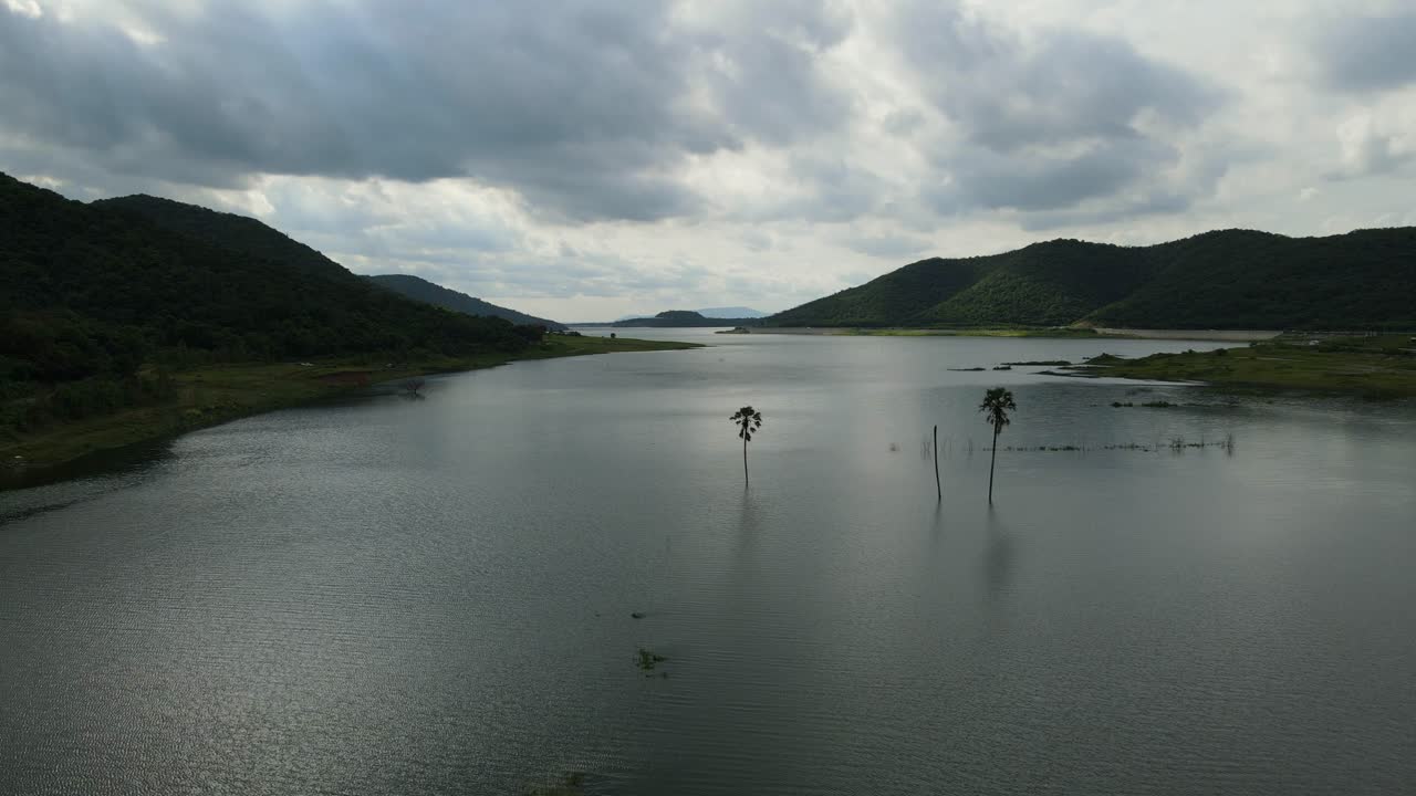 야자수, 아름다운 일몰과 수평선, 차량과 낚시하는 사람들이 있는 언덕 옆 도로, 무악 클렉, 사라부리, 태국을 드러내는 왼쪽으로 공중 슬라이딩 영상