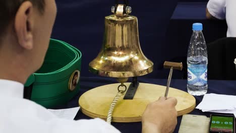 juzgando una competencia con una campana de bronce