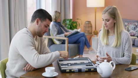 couple playing backgammon at home