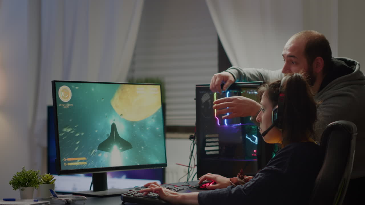 남자 게이머가 여자친구에게 우주 슈팅 비디오 게임을 가르치고 있습니다.