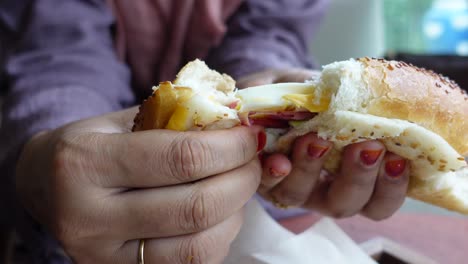 una mujer comiendo un sándwich.