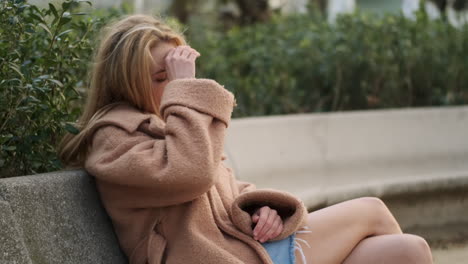 una mujer joven sentada en el parque de la ciudad.