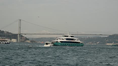 ferry crossing the bosphorus strait under the fatih sultan mehmet bridge in istanbul