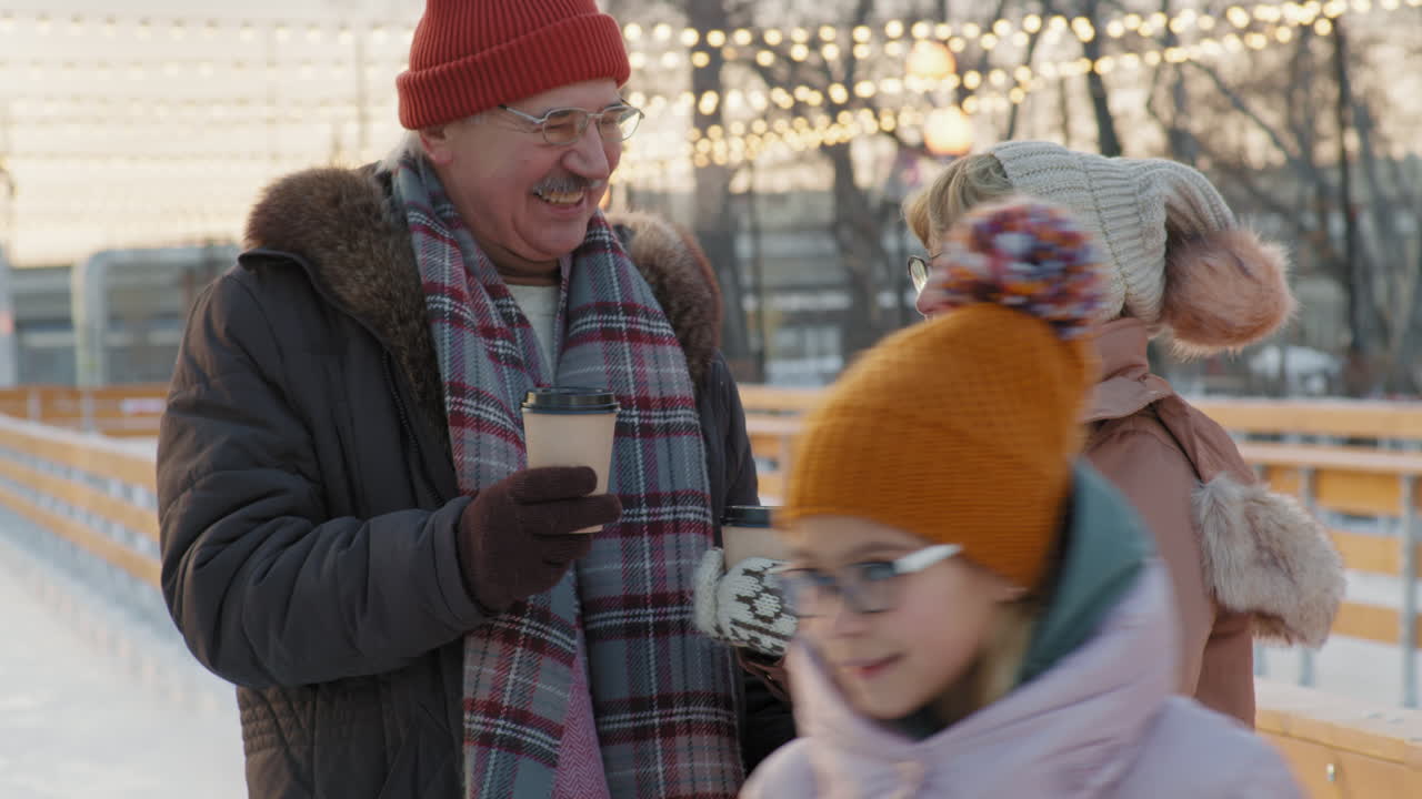 una pareja mayor disfrutando de café en la pista de hielo de invierno