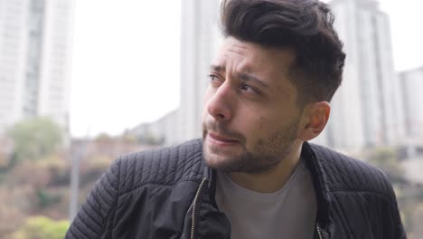 close-up of thoughtful unhappy young man on the street.