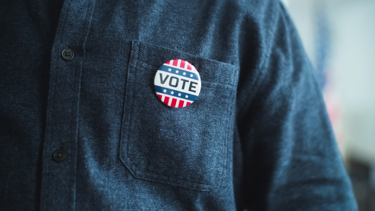 African American us Citizen Puts on Badge with Usa Flag Logo Close up of Anonymous African American Man or us Citizen Putting on Badge with Usa Flag Logo and Inscription i Voted Male Voter at Polling Station after Voting Election Day in the United States