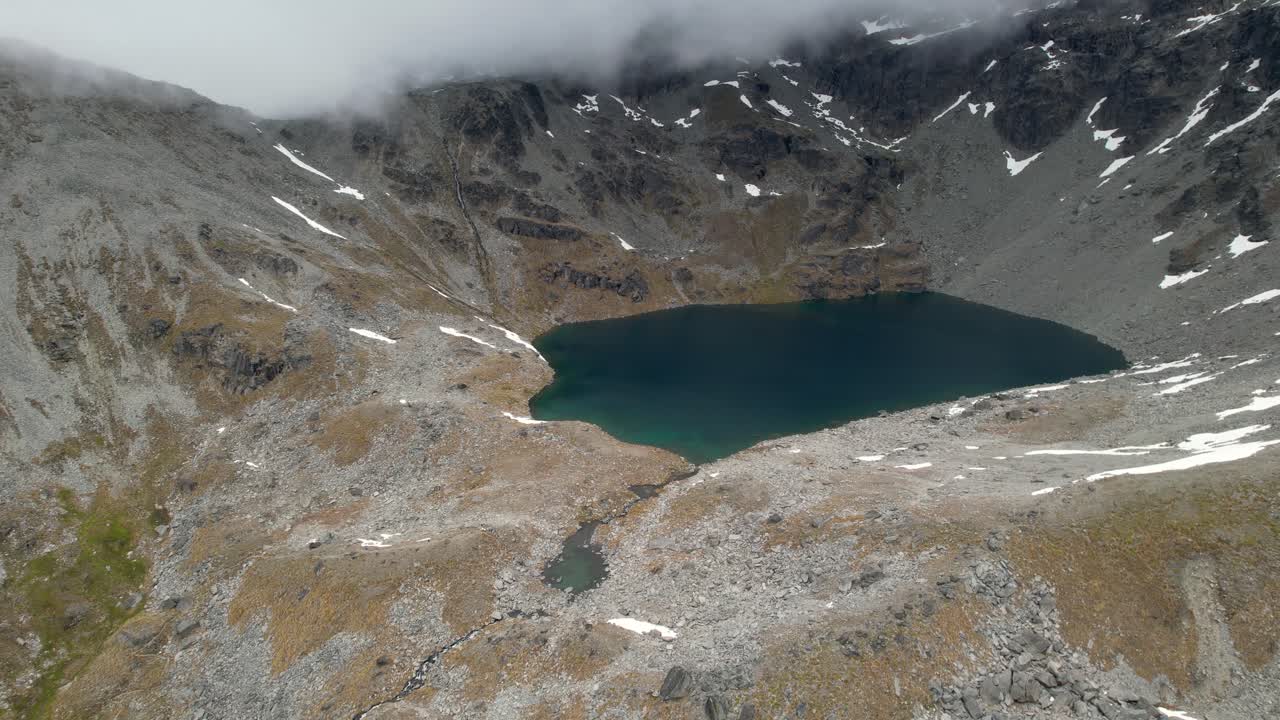 hermoso paisaje de alta montaña de nueva zelanda del lago alta rodeado de picos brumosos, disparo de dron