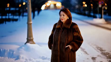 elegant senior woman in fur coat on a snowy night