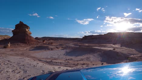 driving through desert terrain filled with hoodoos and sandstone buttes