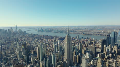 Elevated-view-of-cityscape.-Well-known-Empire-State-Building-with-tall-spire-on-top.-Hudson-River-in-background.-Manhattan,-New-York-City,-USA