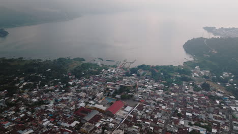 Luftaufnahme:-Langsame-Panoramaaufnahme-Des-Dorfes-San-Juan-La-Laguna-Im-Atitlán-See,-Guatemala,-An-Einem-Bewölkten-Tag