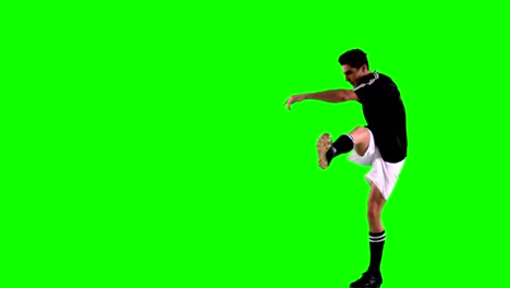 atleta practicando fútbol contra la pantalla verde