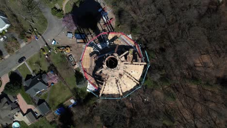 una vista aérea desde arriba directamente sobre una torre de agua siendo desmantelada en un día soleado en long island, nueva york