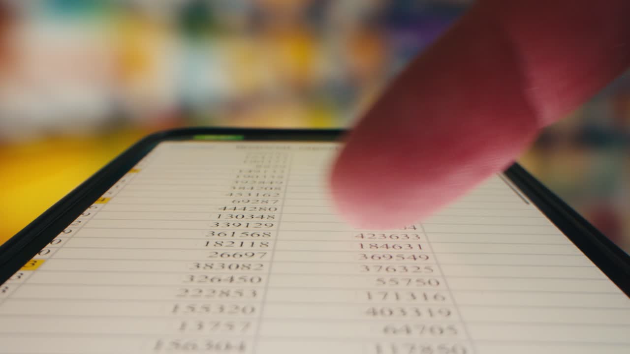 Finger Scrolling Through Financial Data on Smartphone Screen