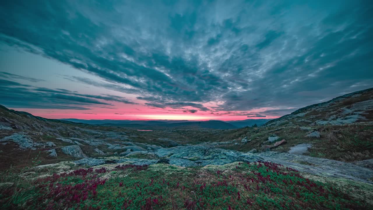 nubes oscuras y tormentosas iluminadas por el sol poniente cuelgan sobre el duro paisaje de la tundra.