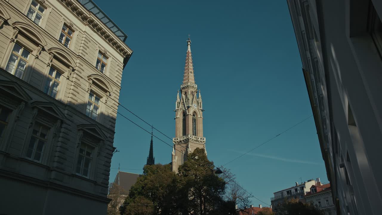 비엔나 의 은 하늘 아래 역사적 인 건물 들 에 둘러싸인 신 고 양식 의 교회 첨탑