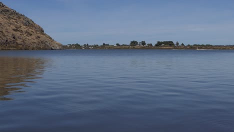 Patterns-in-calm-lake-water-contrast-with-speed-of-power-boats-in-distance---Lake-Forsyth