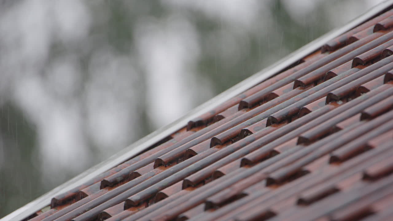 Slow motion, rain falls on a clay tiled house roof, Sweden