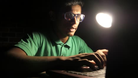 young man working on laptop at night