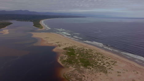 áfrica del sur george mossel bay garden route playa avión no tripulado cinematográfico vacaciones ciudad de vacaciones jeffreys bay olas estrellándose aqua azul marrón océano tarde en la mañana nublado áfrica movimiento hacia adelante