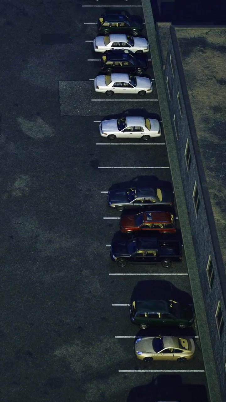 Biler parkeret i rækker på en parkeringsplads nær en bygning om natten.