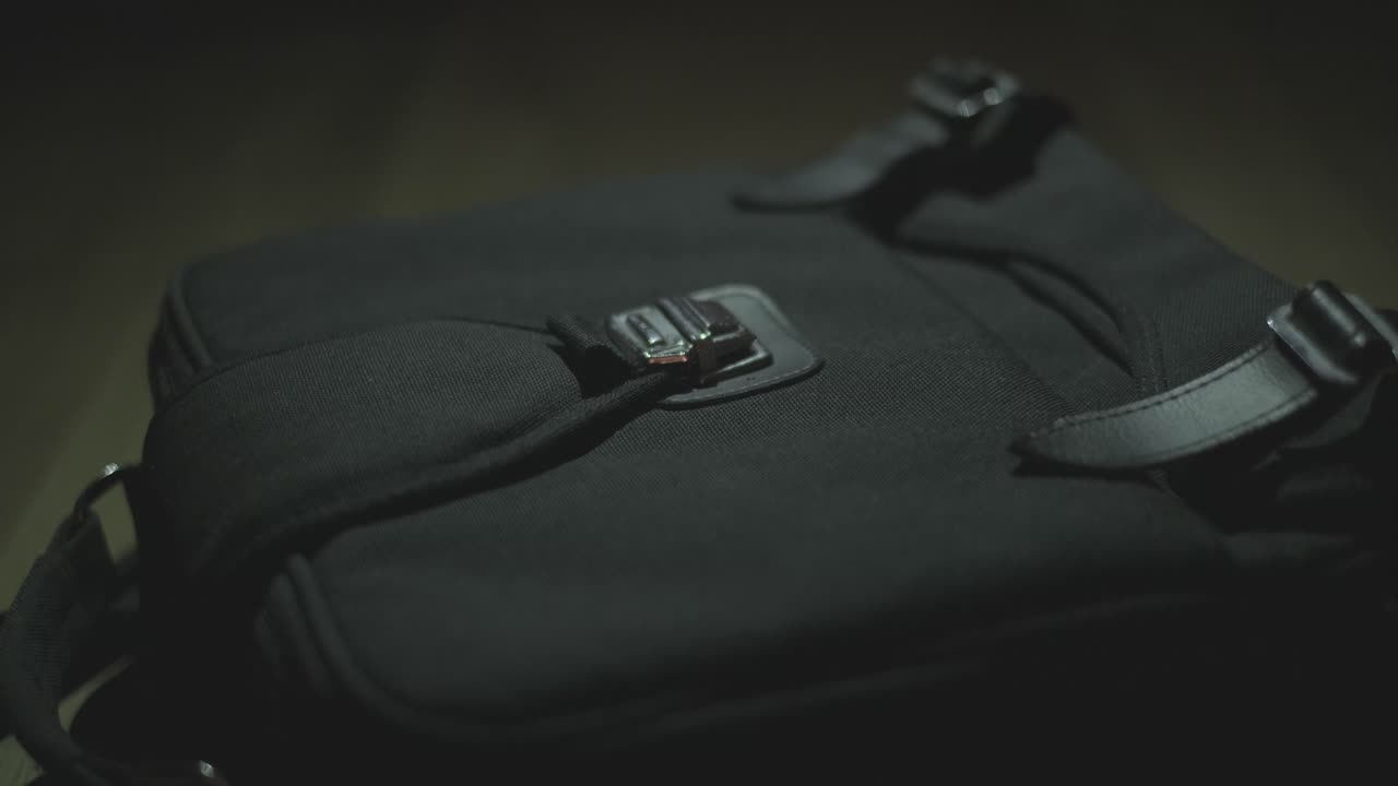 Close-up of a Person's Hand Interacting with a Black Bag