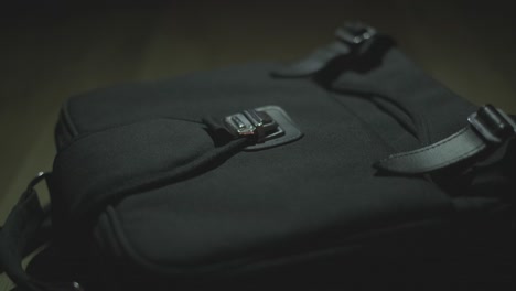 close-up of a person's hand interacting with a black bag