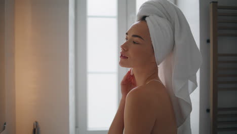 chica tranquila limpiando el cuello en el baño de cerca. mujer segura sosteniendo almohadilla de algodón