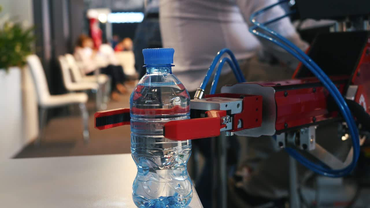 robot industrial que maneja una botella de agua
