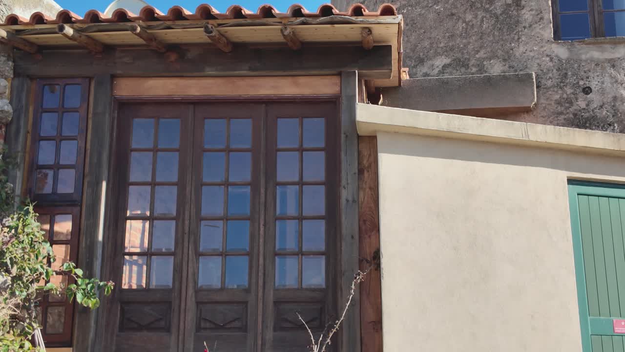 Old stone and brick windmill tower with battlements and antennas on a sunny day in Ferragudo, Portugal