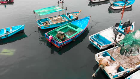 Schwenken-Sie-Die-Luftaufnahme-Von-Ruhenden-Fischerbooten-Zum-Hafen-Der-Stadt-Paracas