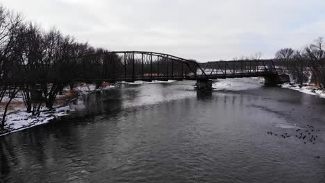 viejo puente sobre el invierno río caudaloso drone