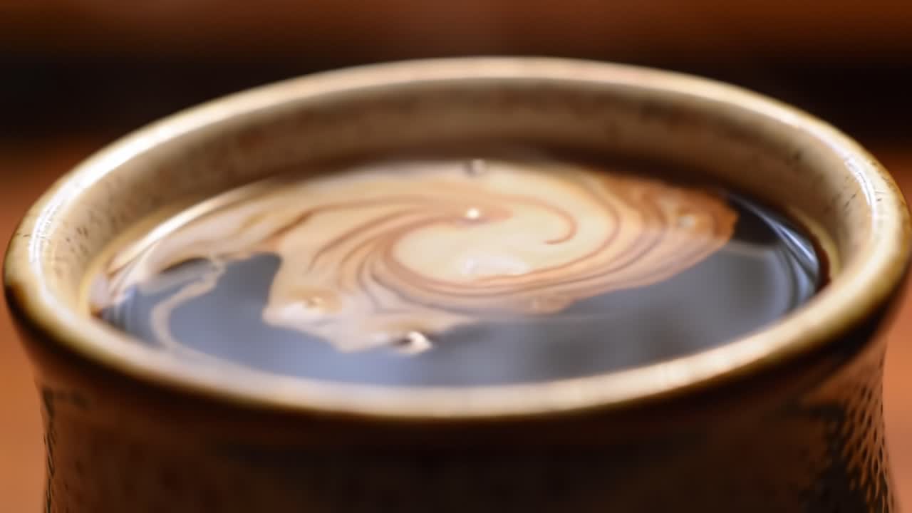 A Captivating Visual Transition of Cream Swirling in Dark Liquid: A Close-Up Journey Through the Artistry of Coffee and Cream Blending Together