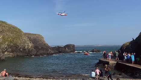 irish coastguard conducts helicopter rescue as people on shore watch