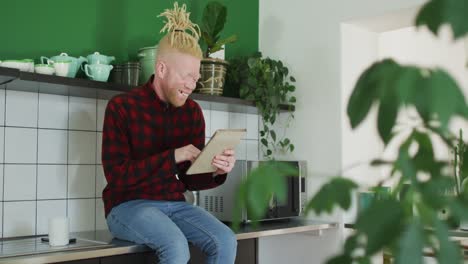thoughtful albino african american man with dreadlocks using tablet