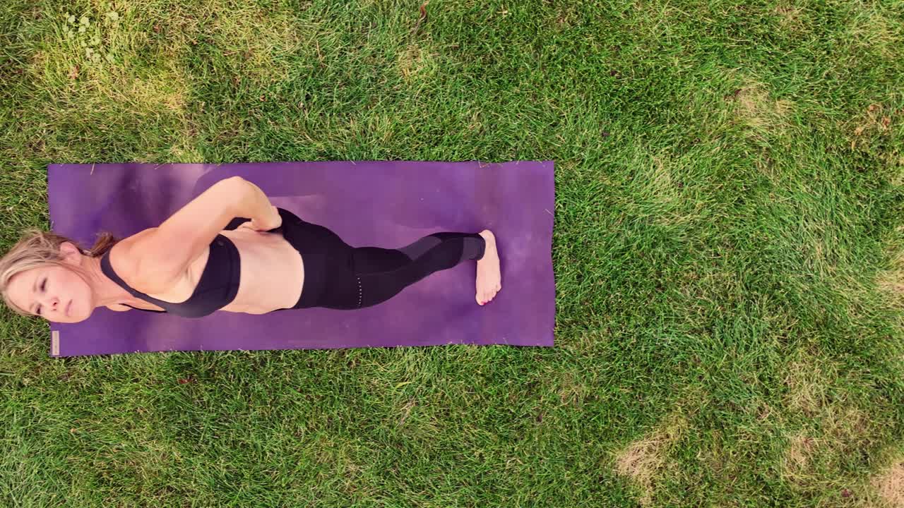 Yoga as an artform a woman illustrate heroic poses while doing yoga in a park. Drone 4k