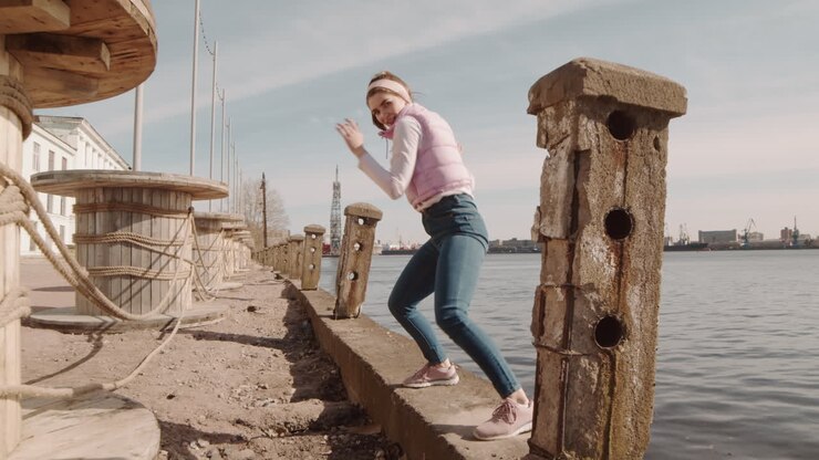 Kvindelig performer, der danser ved søbredden