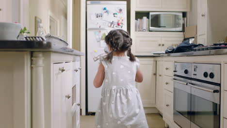 niña feliz tomando galletas niño furtivo robando galletas en la cocina en casa