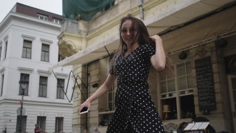 woman in a polka dot dress walking through a city street