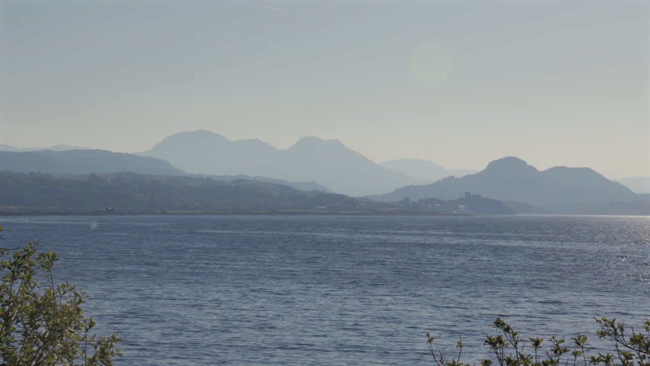 Distant shot of Eryri National Park Snowdonia with Castle Harlech at Hafan y Môr on Pen-y-chain, Pwllheli